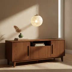 Alabaster ball pendant light hanging above mid-century modern wooden sideboard with green vase and books