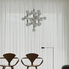 Modern chandelier with globe bulbs above designer chairs in a minimalist living room