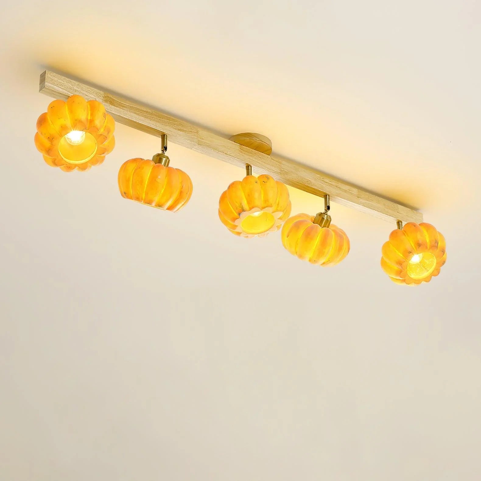 Modern ceiling lamp with five pumpkin-shaped yellow lampshades on a wood bar by YH Lamps