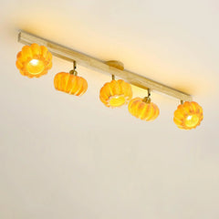 Modern ceiling lamp with five pumpkin-shaped yellow lampshades on a wood bar by YH Lamps