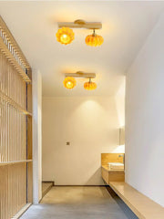 Modern pumpkin-shaped yellow wood ceiling lamps lighting a minimalist hallway from YH Lamps