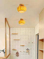 Modern yellow pumpkin ceiling lamps with wood accents in a stylish, minimal home interior