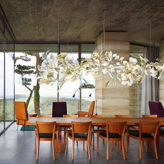 Modern dining room with large wooden table, wooden chairs, and gold white ginkgo chandelier from YH Lamps