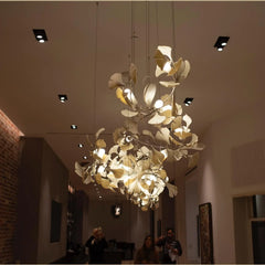 Modern gold and white ginkgo leaf chandelier with multiple bulbs hanging in stylish indoor space