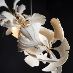 Modern gold and white Ginkgo leaf chandelier with elegant curved petals, soft lighting against dark background