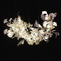 Modern gold and white ginkgo leaf chandelier with multiple lights on black background