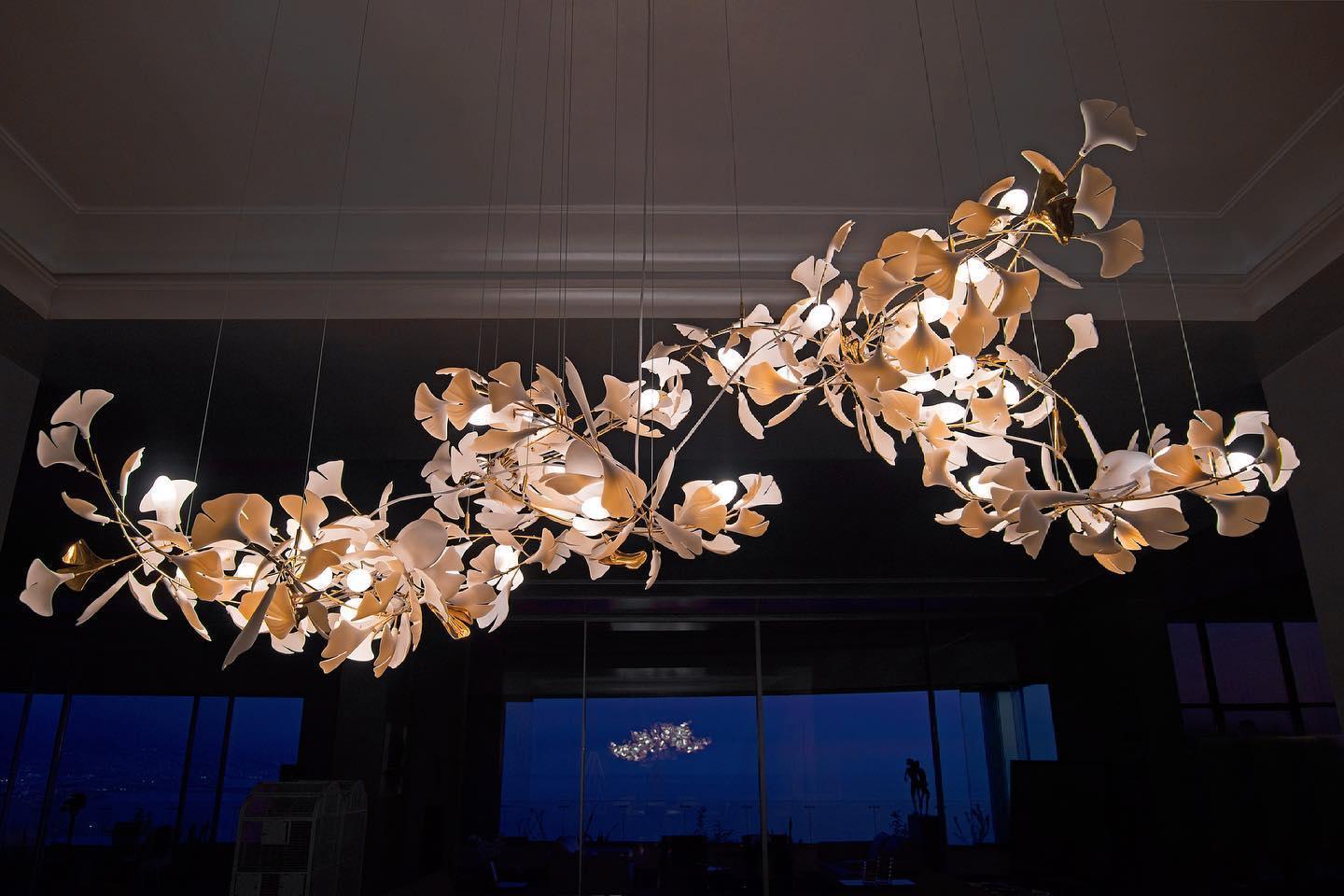 Modern gold and white gingko leaf chandelier with multiple pendant lights in a stylish interior