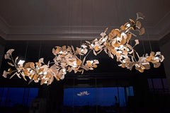 Modern gold and white gingko leaf chandelier with multiple pendant lights in a stylish interior