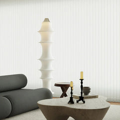 Modern white sculptural floor lamp in a minimalist living room with designer furniture