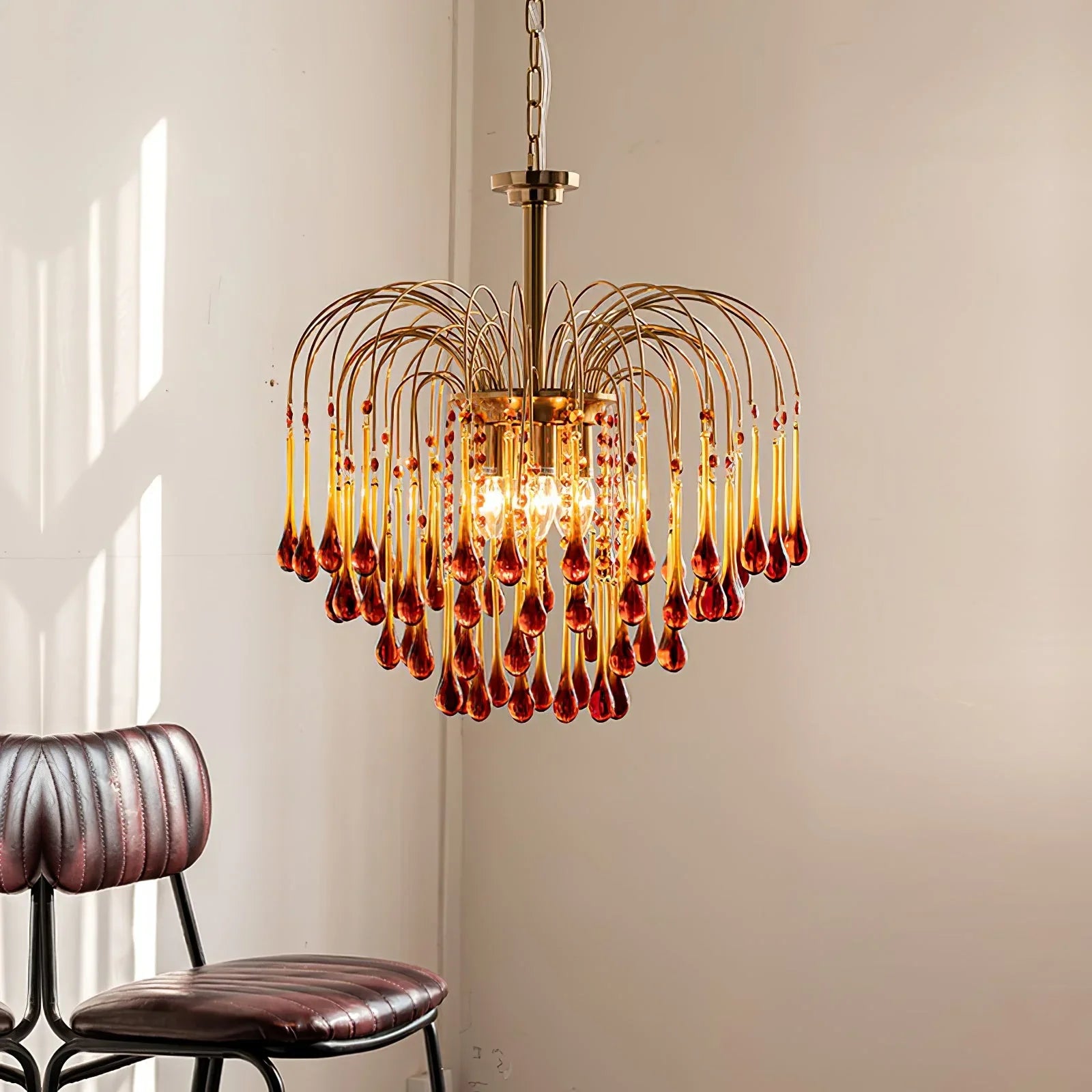 YhLamps brass chandelier with amber glass droplets hanging in minimalist room with leather chairs
