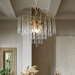 Modern brass chandelier with clear maltose glass drops hanging in elegant beige interior