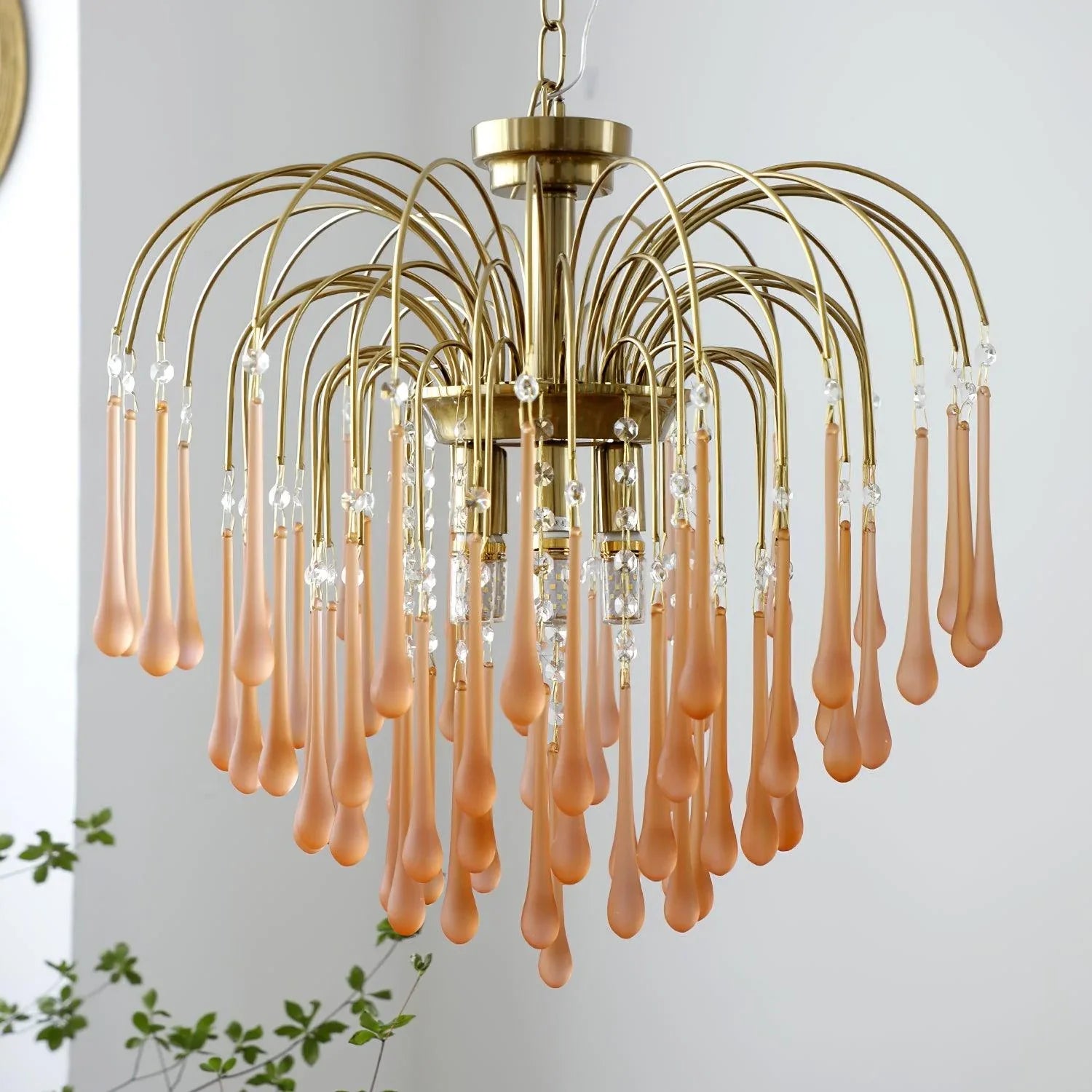 Modern brass chandelier with curved arms and amber glass droplets, contemporary pendant lamp from YhLamps
