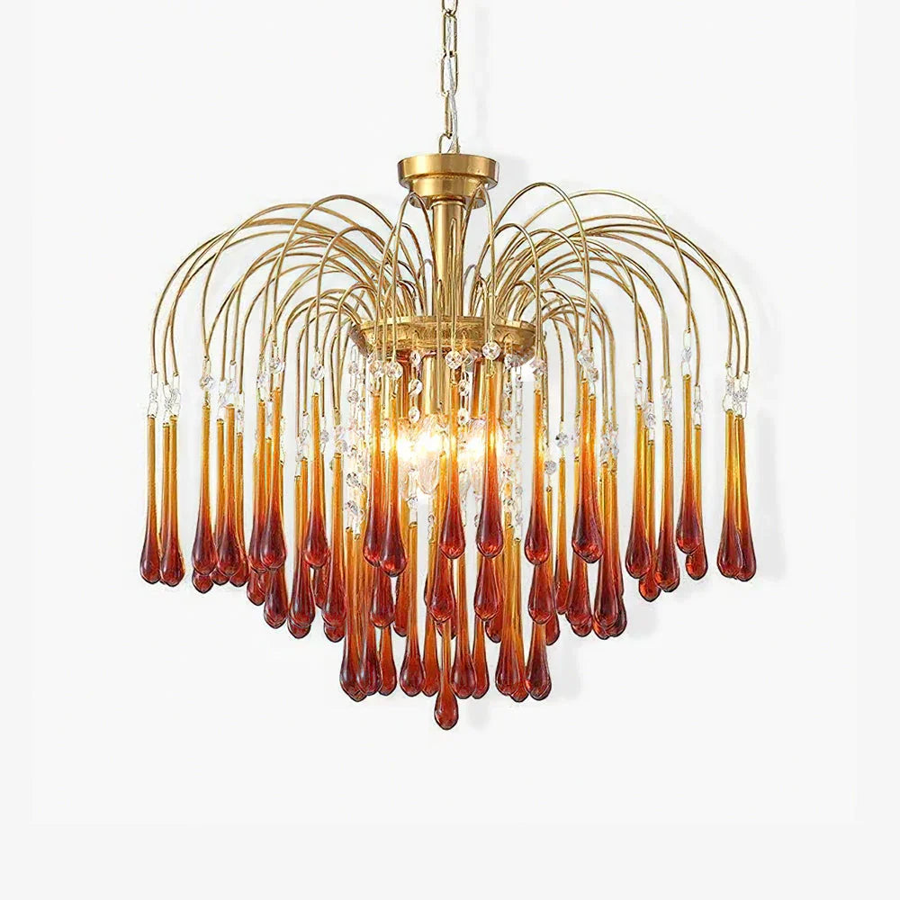 Modern brass chandelier with amber glass teardrop pendants and crystal accents hanging from curved arms