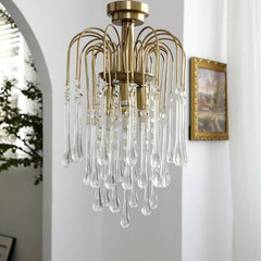Modern brass chandelier pendant lamp with clear crystal glass droplets in a bright room