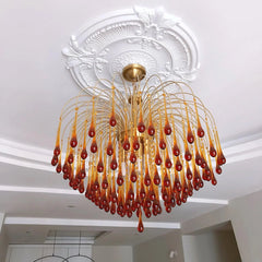 Modern brass chandelier with amber glass droplets hanging from ceiling medallion in elegant living space