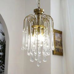 Modern brass chandelier pendant lamp with clear glass droplets, hanging in elegant living space
