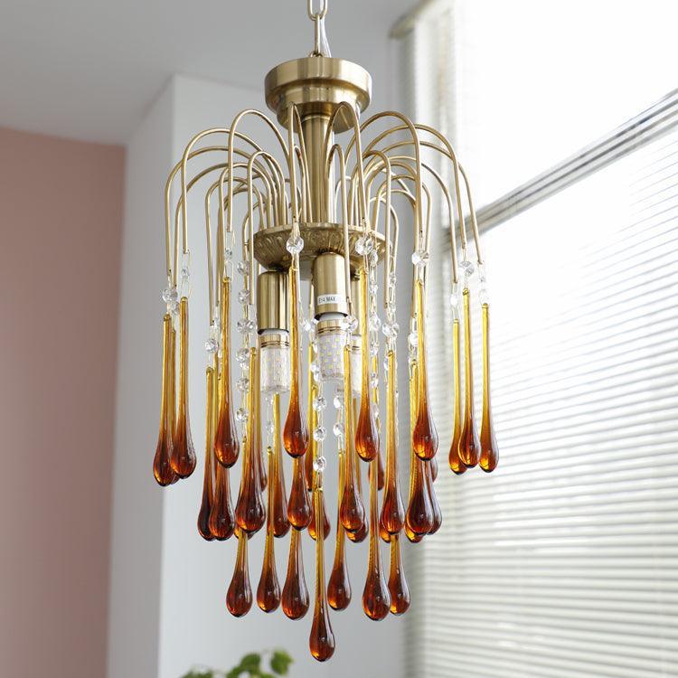 Modern brass chandelier pendant lamp with amber maltose glass drops and crystal accents, stylish home lighting