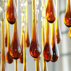 Close-up of amber glass drops on YhLamps modern pendant chandelier with brass accents