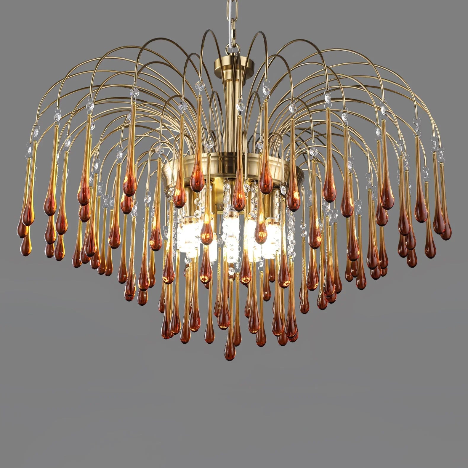 Modern brass chandelier with amber glass teardrops and hanging crystal accents by YhLamps