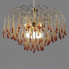 Modern brass chandelier with amber glass teardrops and hanging crystal accents by YhLamps