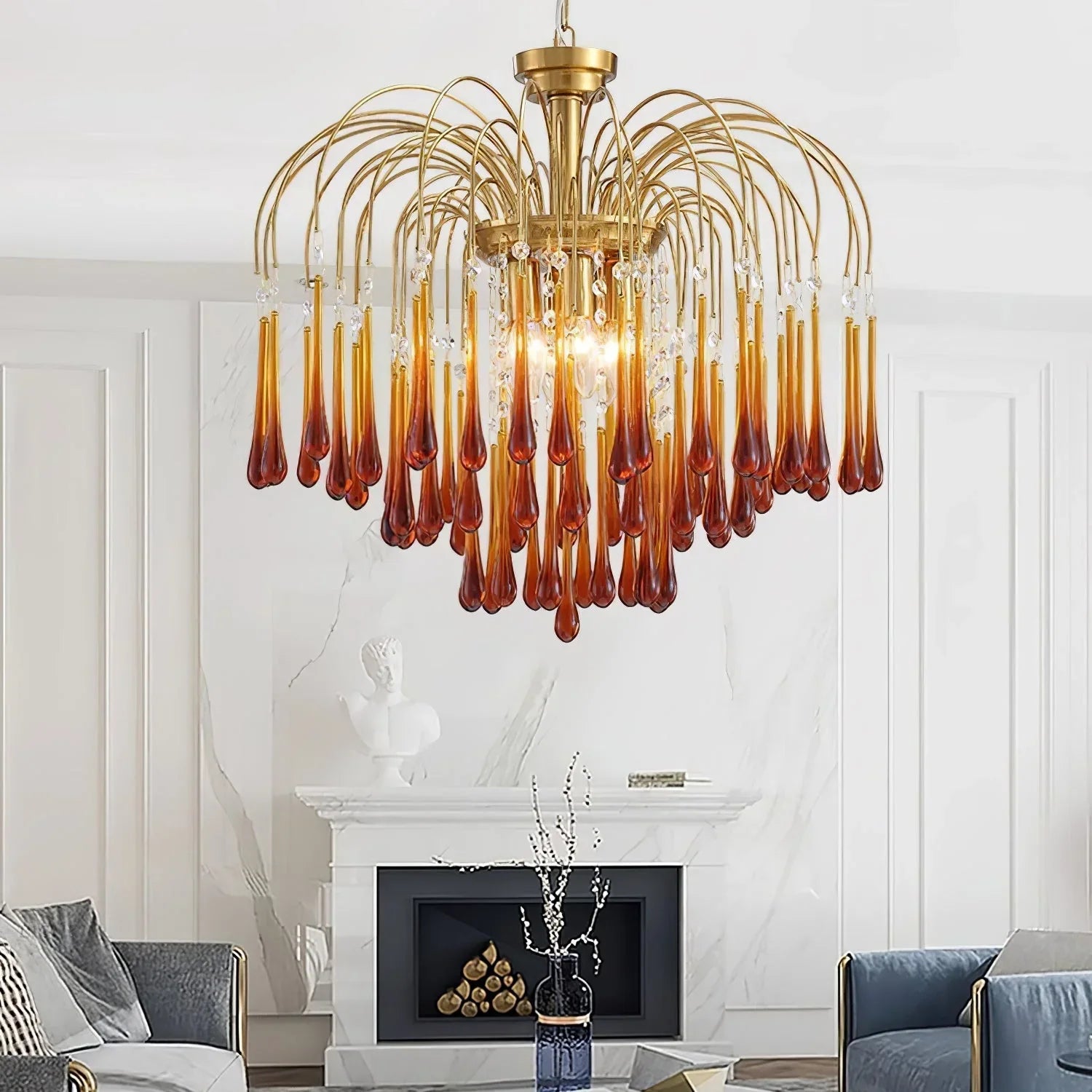 Modern brass chandelier with amber glass teardrop pendants in elegant living room featuring white marble fireplace