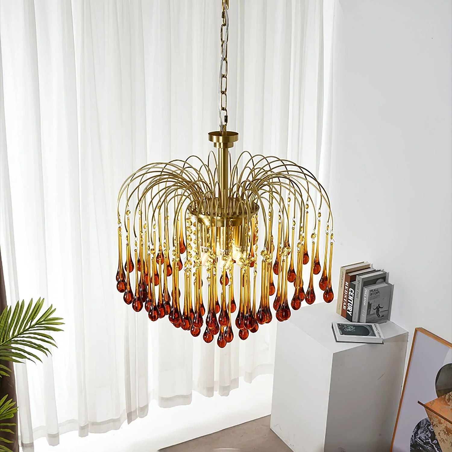 Modern brass chandelier with amber glass teardrop pendants hanging in a stylish living space