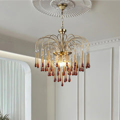 Modern brass chandelier with amber glass droplets, elegant pendant lamp in stylish white room