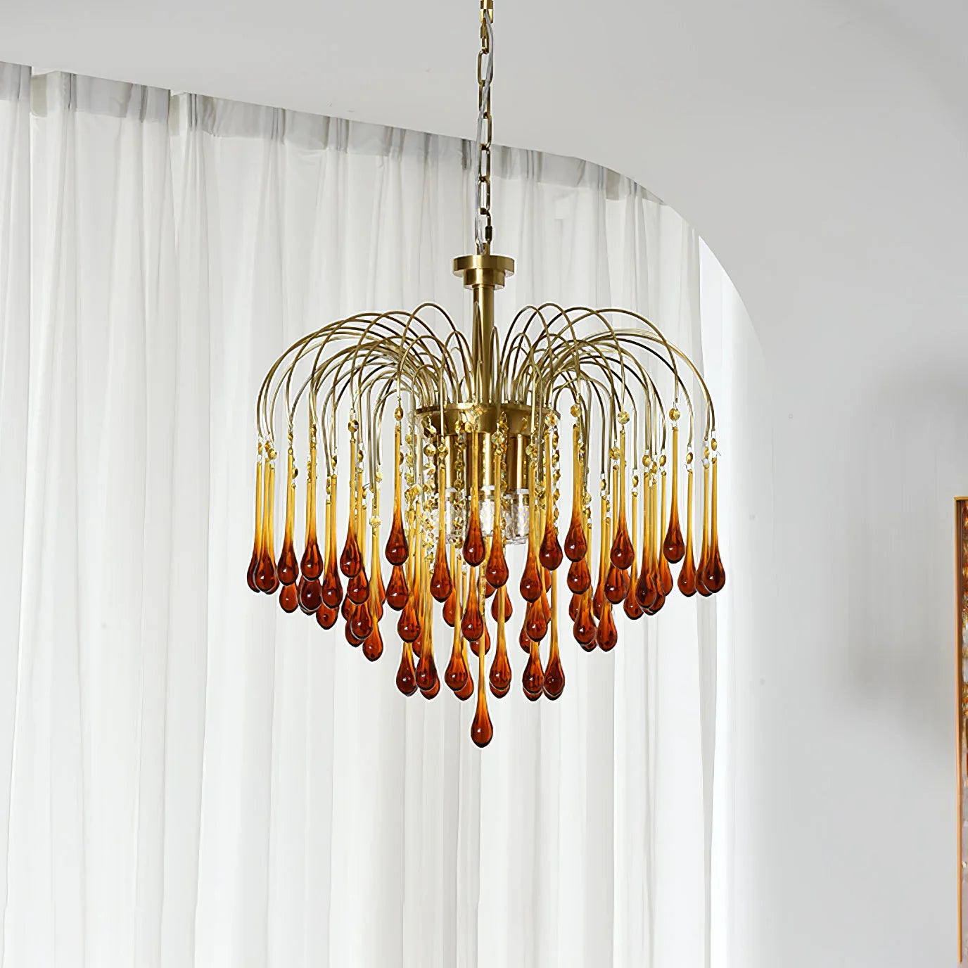 Modern brass chandelier pendant lamp with hanging amber glass teardrops in elegant room