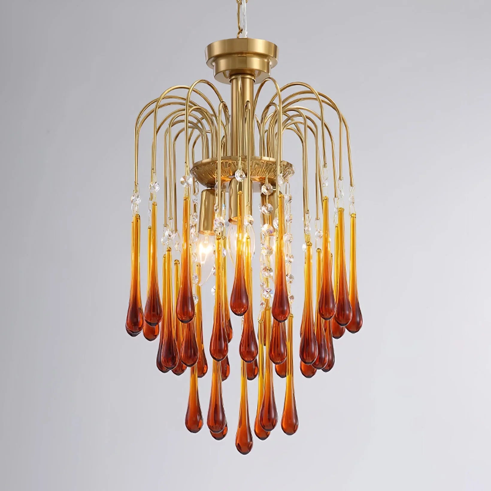 Modern brass chandelier with amber glass teardrop pendants and crystal accents from YhLamps