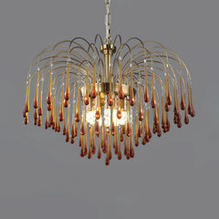Modern brass chandelier with amber glass droplets and crystal accents suspended on chain
