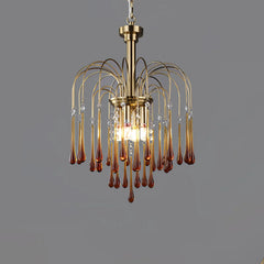Modern brass chandelier pendant lamp with amber glass droplets and clear crystal accents on gray background