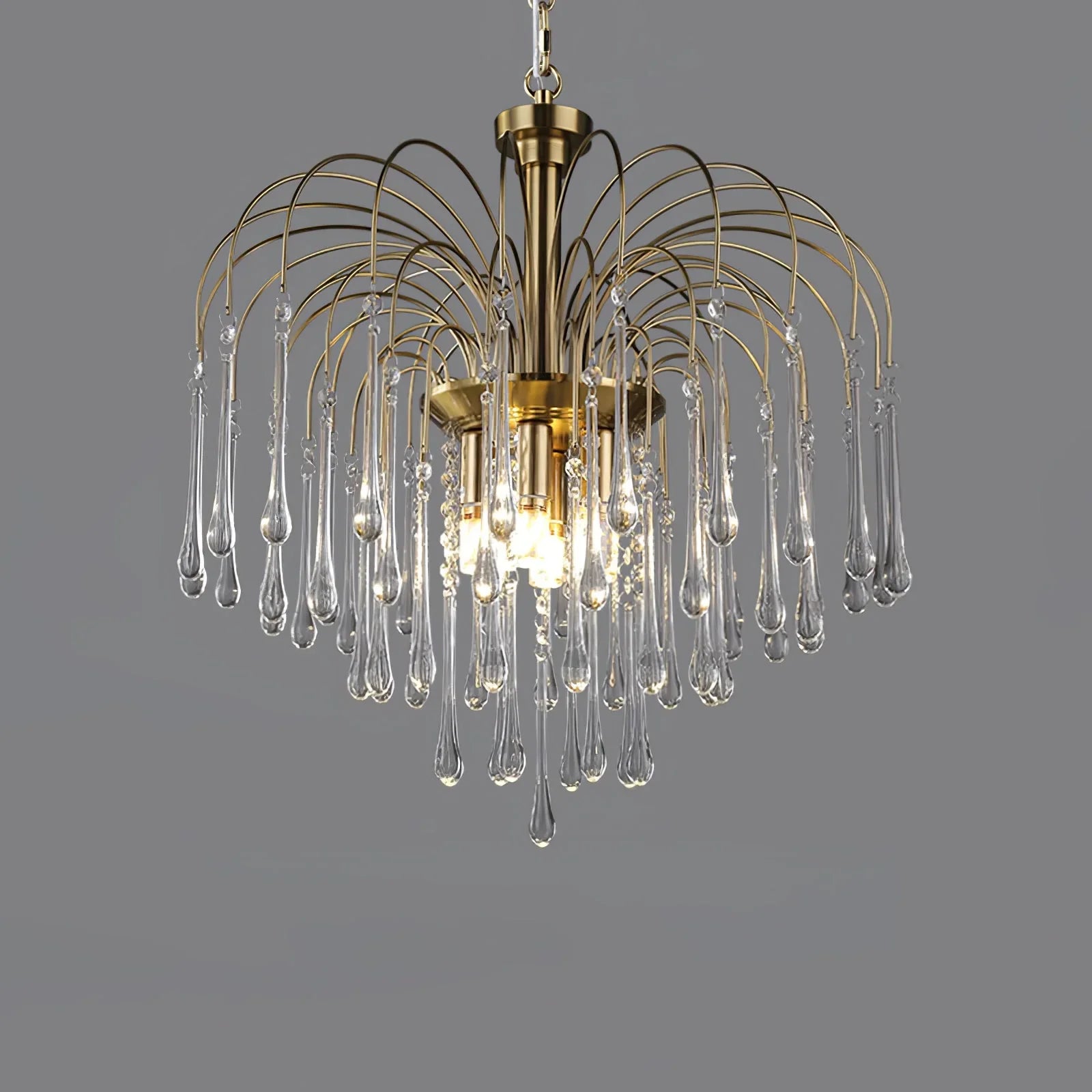 Modern brass chandelier pendant lamp with clear glass teardrop crystals on gray background
