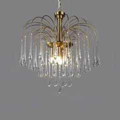 Modern brass chandelier pendant lamp with clear glass teardrop crystals on gray background