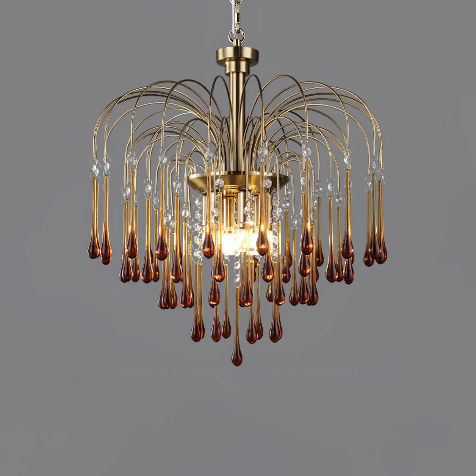 Modern brass chandelier pendant lamp with amber glass droplets and clear crystals on gray background