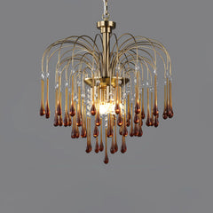 Modern brass chandelier pendant lamp with amber glass droplets and clear crystals on gray background