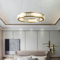Modern brass and white alabaster circular pendant chandelier in elegant bedroom with minimalist wall lights