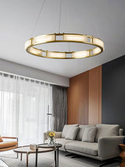 Modern circular brass and alabaster pendant chandelier over gray sofa in stylish living room