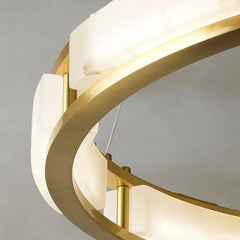Close-up of modern brass chandelier with white alabaster diffusers and warm light from YH Lamps