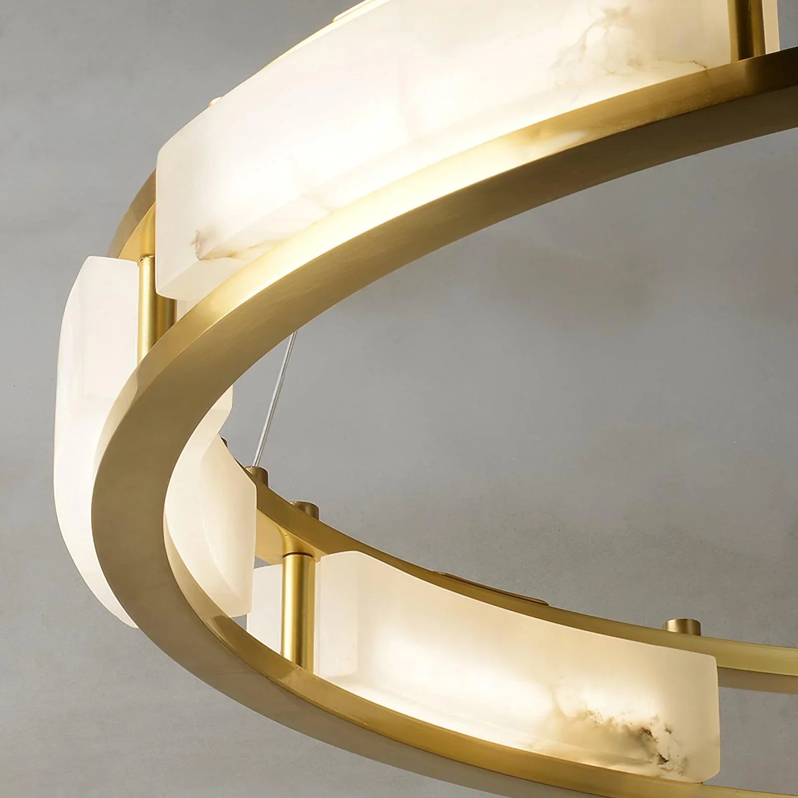 Modern brass chandelier with circular frame and warm white alabaster light panels, elegant home lighting