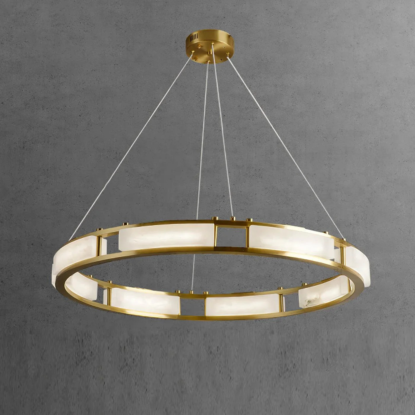 Modern brass circular pendant chandelier with alabaster panels suspended by white cords against gray background