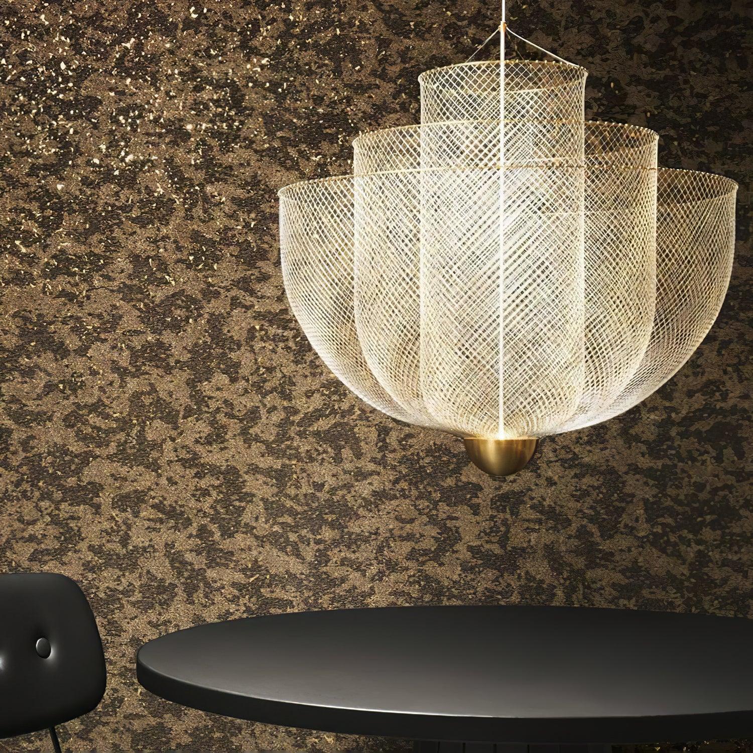 Modern gold-based pendant lamp with warm light mesh design hanging above black table and chair