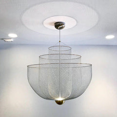 Modern pendant chandelier with layered mesh shades, chrome body, and gold base, emitting warm light