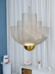 Modern pendant chandelier with layered gold mesh shades and a gold base, hanging over white marble console