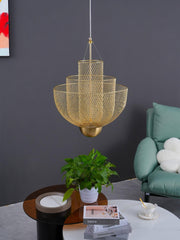 Modern gold mesh pendant chandelier hanging over round tables with green plant and books in stylish living room
