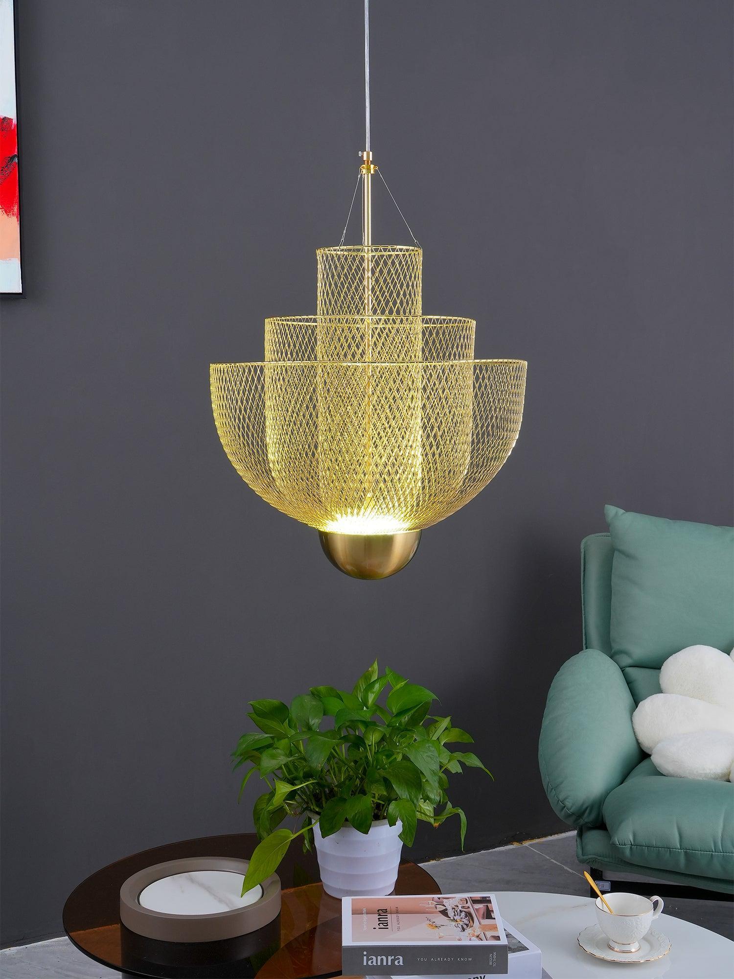 Modern gold mesh pendant chandelier lamp hanging in stylish living room with green sofa and coffee table