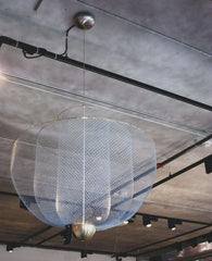 Modern large mesh pendant chandelier with chrome lamp body and gold base hanging from industrial ceiling