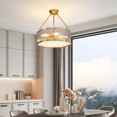 Modern brass pendant chandelier by YH Lamps in an elegant dining room with large window view.
