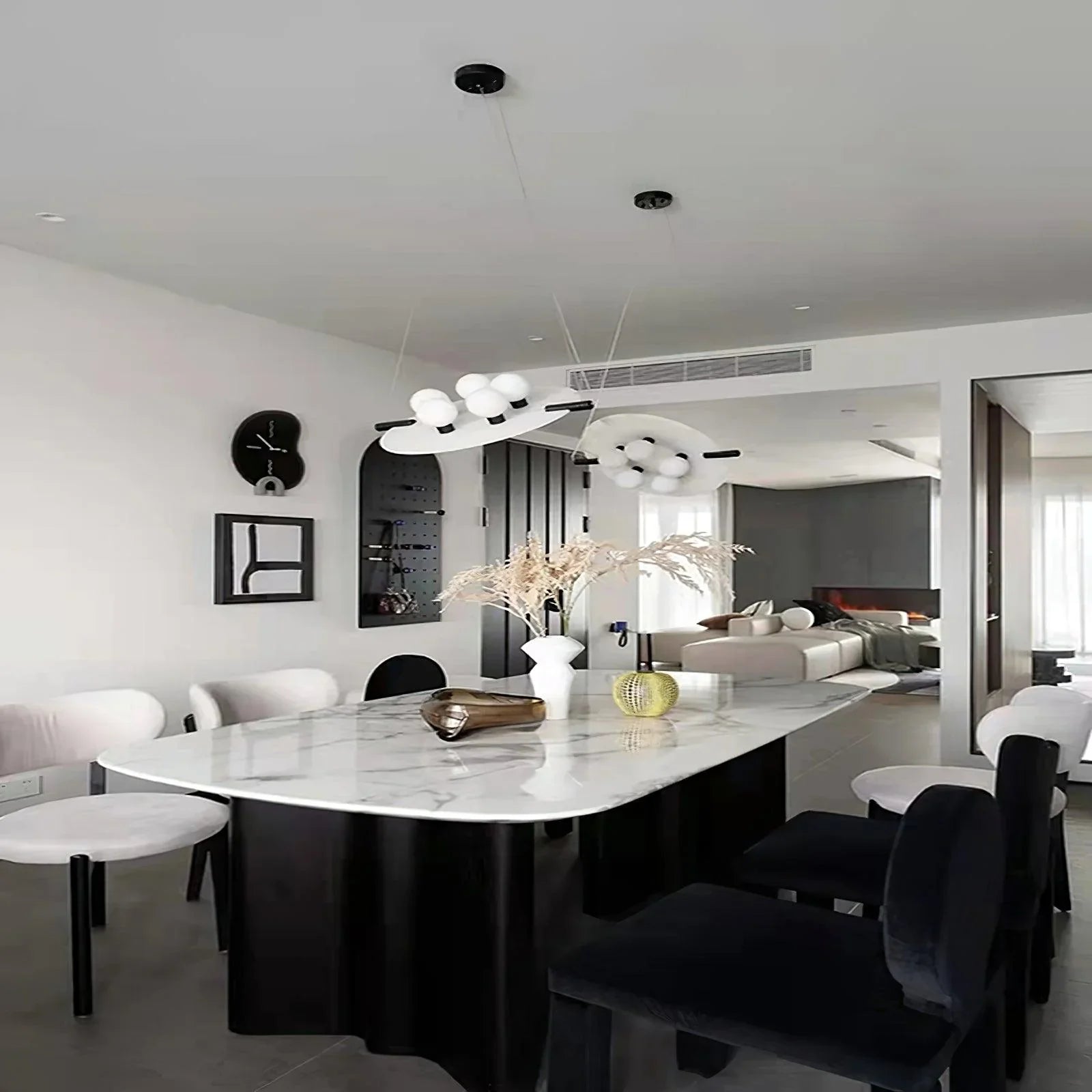 Modern dining room with black and white chairs, marble top table, and unique black and white pendant chandelier