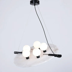 Modern black and white pendant chandelier with five glowing round bulbs on a circular marble plate