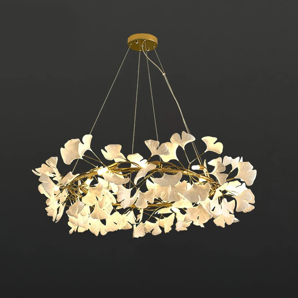 Modern gold and white ginkgo leaf chandelier pendant lamp with warm lighting against dark background